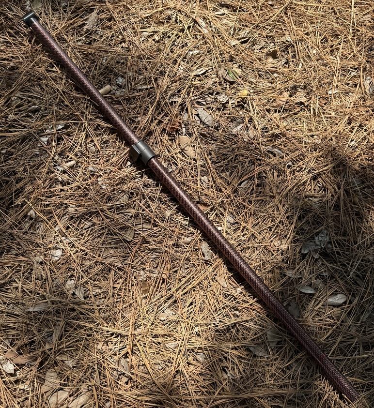 A Minelab Equinox 700/900 two-piece carbon-fiber lower shaft in red/black, showing the clamp-type cam lock that joins the middle and lower sections